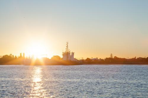 Ship coming into Newcastle Harbour at sunset