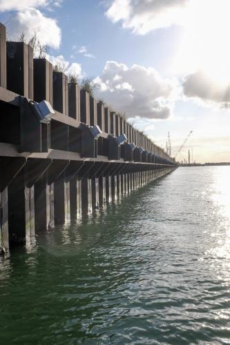 ship loading dock and cranes with sun shining through clouds - Australian Stock Image