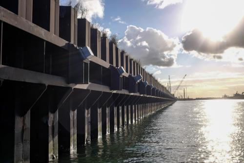 ship loading dock and cranes with sun shining through clouds - Australian Stock Image