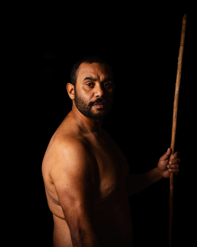 Shirtless aboriginal man holding a wooden spear - Australian Stock Image