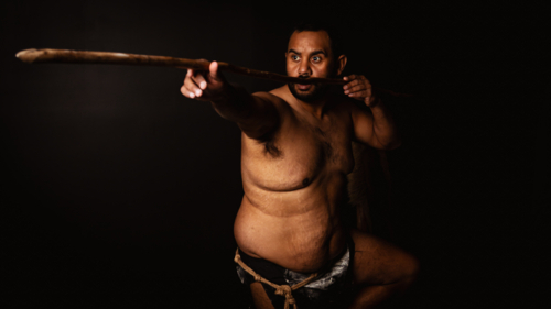 Shirtless aboriginal man holding a wooden spear - Australian Stock Image
