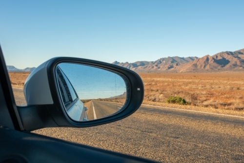 Side mirror of car showing road through Flinders Ranges, SA - Australian Stock Image