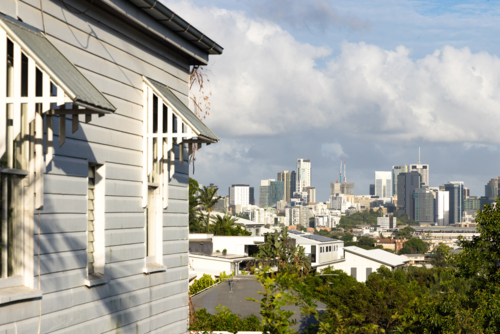 Side of a weatherboard Queenslander style home with a view towards the Brisbane city skyline - Australian Stock Image