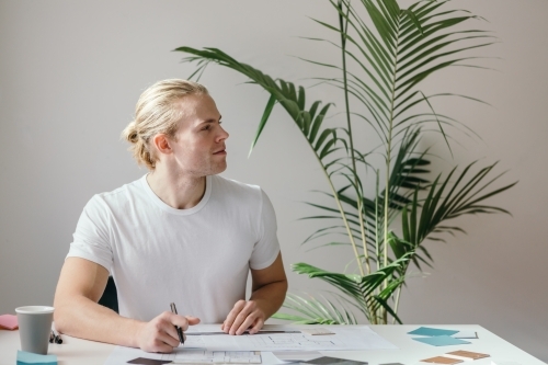 Side profile of a man sitting behind the desk - Australian Stock Image