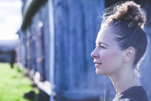 Side profile of a middle aged woman with her hair in a bun - Australian Stock Image
