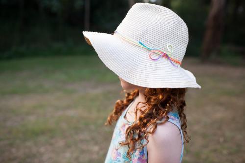 Side view of a young girl wearing a floppy hat