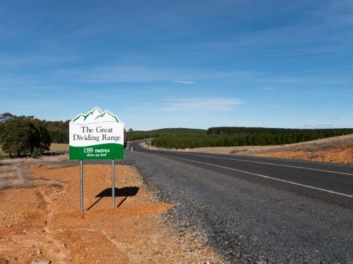 Sign on a bitumen road marking "The Great Dividing Range" - Australian Stock Image