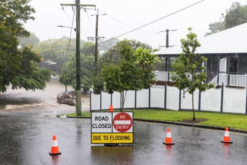 Signage across a flooded suburban road to stop traffic proceeding during a major rain event - Australian Stock Image