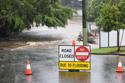 Signage across a flooded suburban road to stop traffic proceeding during a major rain event - Australian Stock Image
