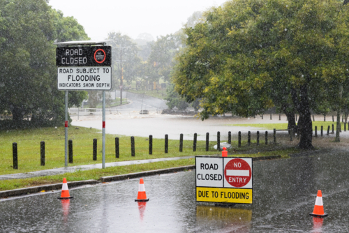 Signage on a road showing it is closed due to flooding in suburban Brisbane - Australian Stock Image