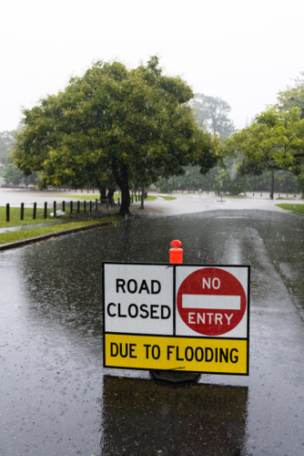 Signage on a road showing it is closed due to flooding in suburban Brisbane - Australian Stock Image