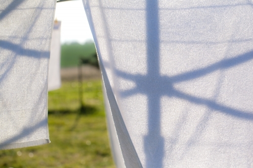 silhouette of a hills hoist washing line against washing - Australian Stock Image