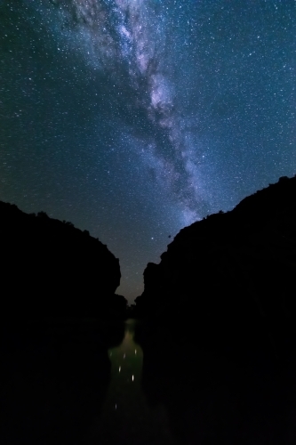 Silhouette of cliffs with night sky with milky way and stars