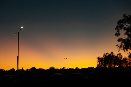 Silhouette of commercial airplane flying in the sky at sunset. - Australian Stock Image