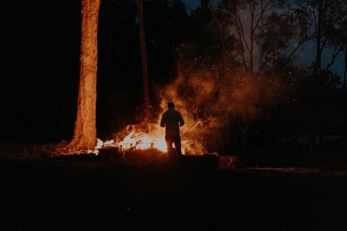 Silhouette of man standing at fire