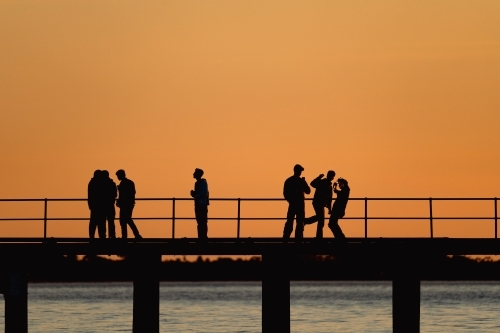Silhouette of people on pier - Australian Stock Image