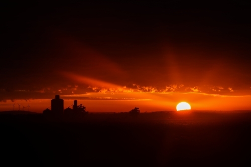 silhouette shot of sunset with orange and black skies - Australian Stock Image