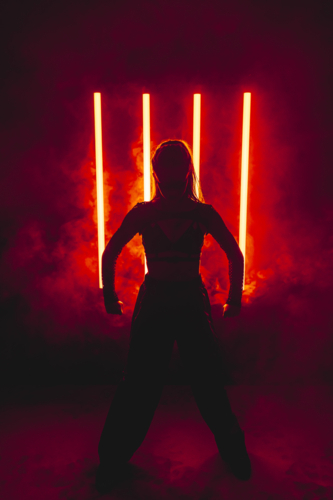 Silhouette Woman with Red Neon Light Bars and Smoke - Australian Stock Image