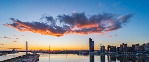 Silhouettes of city buildings in Melbourne's docklands at sunset - Australian Stock Image
