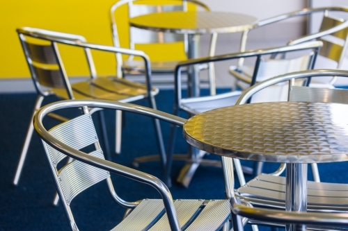 silver chairs and tables in an empty cafe - Australian Stock Image