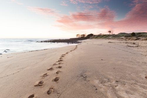 Single set of footprints along the beach in the early morning