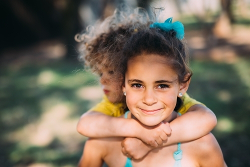 Sister carrying brother on her back