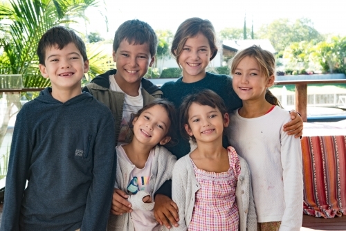 Six diverse culture children standing together smiling at camera. - Australian Stock Image
