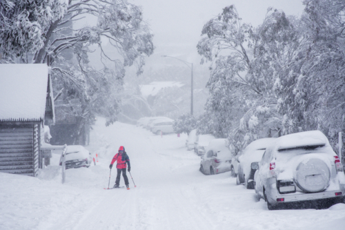 Skiier skiing on road in the snow - Australian Stock Image