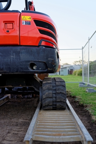 Small excavator red mini digger at a construction site - Australian Stock Image