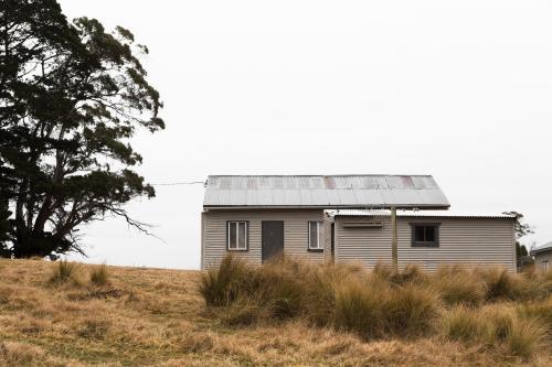 Small farm buildings with long grass and trees - Australian Stock Image