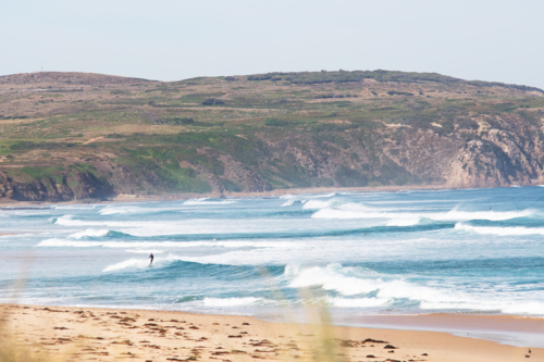Small lone surfer in big surf - Australian Stock Image