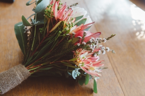 Small posy of native flowers, sitting on a wooden table - Australian Stock Image