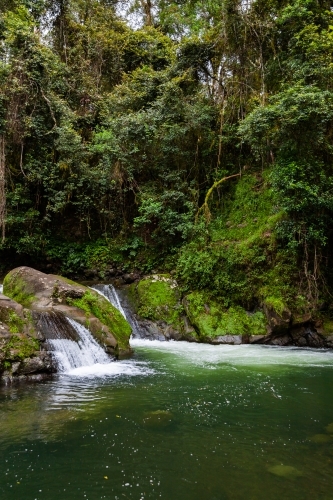 Small waterfall into tranquil green pool on Allyn River - Australian Stock Image