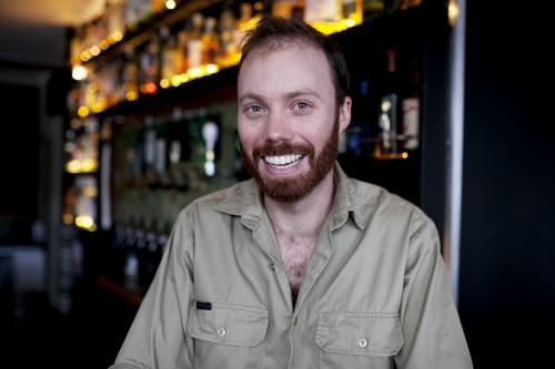 Smiling bartender behind the bar at local craft beer pub