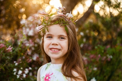 Smiling child with jasmine flower crown in the garden - Australian Stock Image