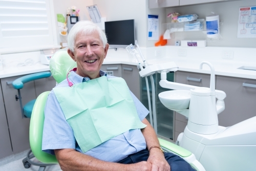 Smiling elderly male patient in dental office