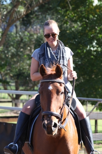 Smiling girl riding horse - Australian Stock Image