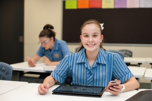 Smiling high school student working in a classroom - Australian Stock Image