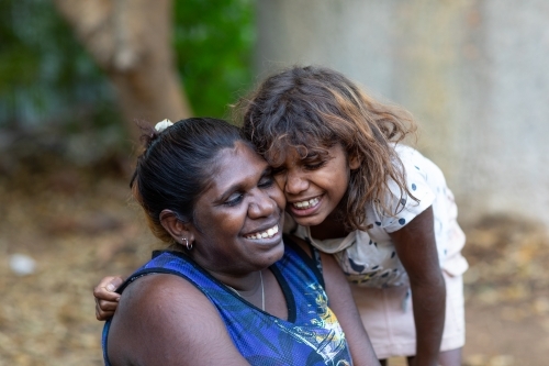 Smiling Indigenous mother and daughter with their faces close together - Australian Stock Image