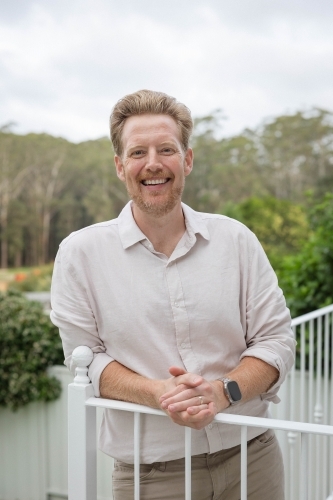 Smiling middle aged man on balcony - Australian Stock Image