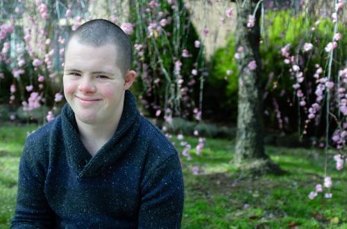 Smiling Young Man seated in his Front Garden - Australian Stock Image