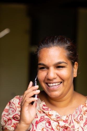 smiling young woman talking on flip-phone - Australian Stock Image