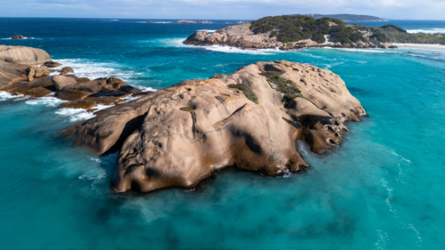 Smooth rounded boulders in a turquoise sea - Australian Stock Image