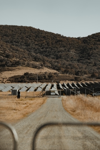 Solar farm panels for renewable energy behind a closed gate.
