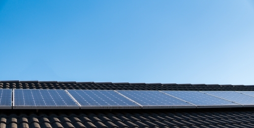 Solar panels installed on roof, blue sky background. Green clean energy - Australian Stock Image