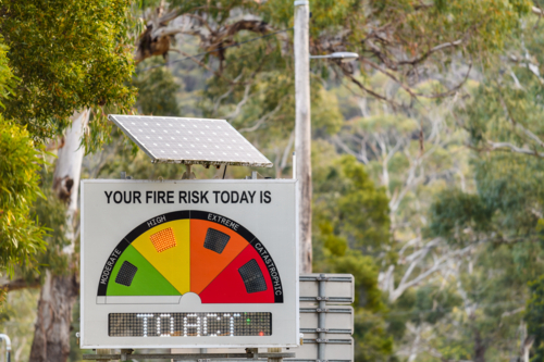 Solar powered fire danger status and bush fire risk sign installed on public roadside showing high - Australian Stock Image