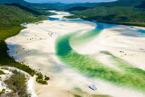 Solitary boat rests in shifting green sands at Whitehaven Beach. - Australian Stock Image