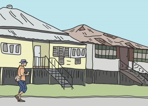 Solitary man walking along street past old houses with coffee in hand - Australian Stock Image
