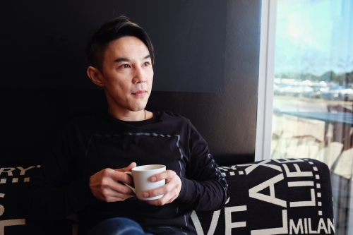 Southeast Asian multicultural man drinking coffee - Australian Stock Image