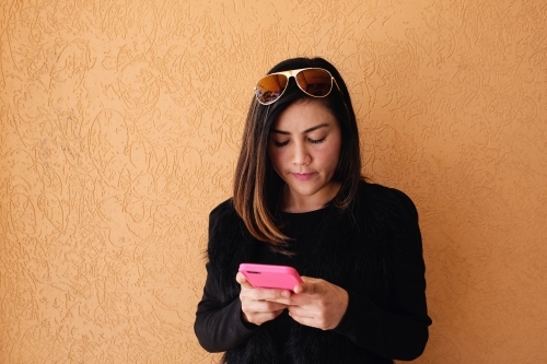Southeast Asian multicultural woman using mobile phone - Australian Stock Image